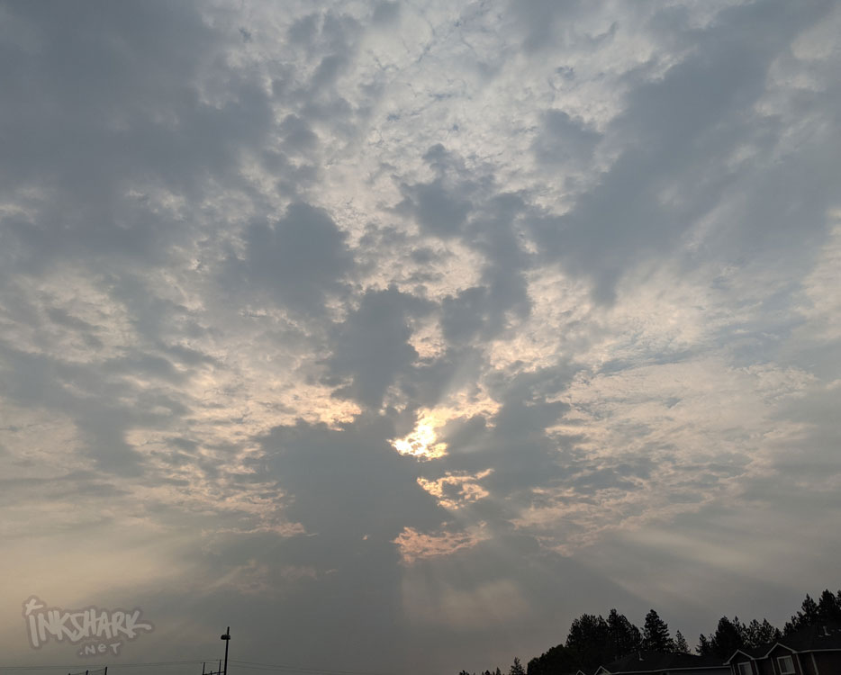 sun behind clouds in a smoky sky