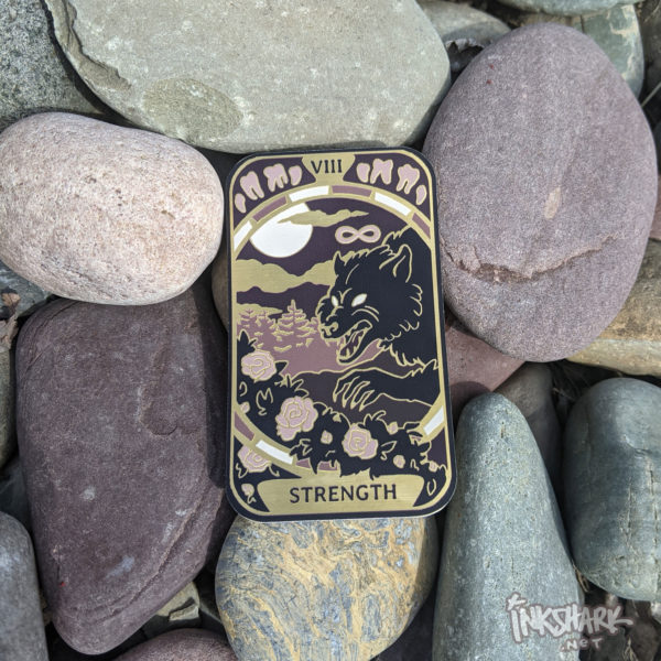 Sticker featuring a werewolf on the Strength card from the Cryptid Tarot. The sticker is posed on some rocks.