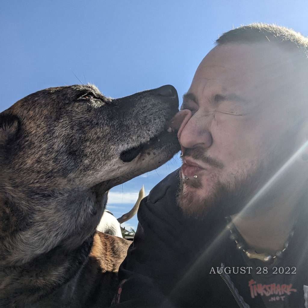 my elderly dog Briar licking my eyeball while i scrunch my face up but still make smoochy lips