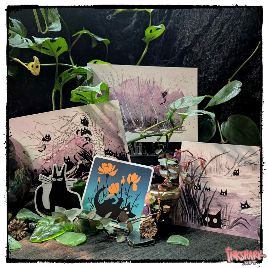 all the postcards and stickers that feature black cats arranged on a mound of worn seaglass and crowned in vines