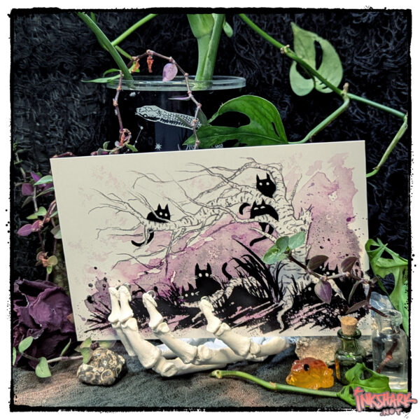 Postcard featuring several black kitties haunting a spooky tree, posed on a repro skeleton hand and surrounded by witchy things and foliage