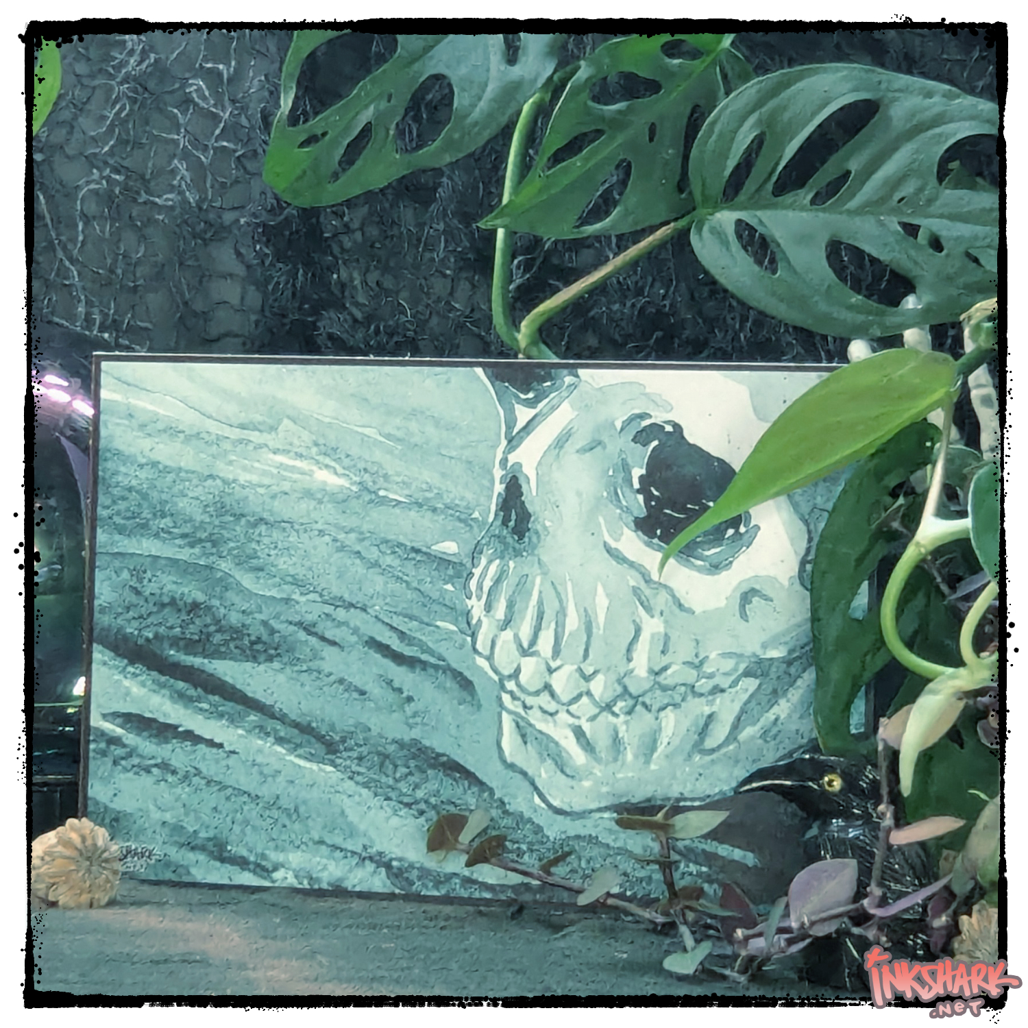 Postcard of an ink wash skull all in turquoise; product posed between a crystal ball and live plants