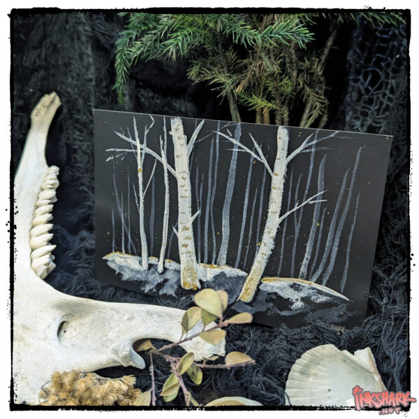 Postcard of four eerie winter birch trees; product is posed under a fir surrounded by (ethically sourced) animal bones and sea shells