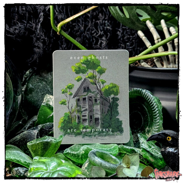 Sticker of a grey abandoned house bursting with healthy foliage, posed on a small hill of worn sea glass that's framed with live foliage