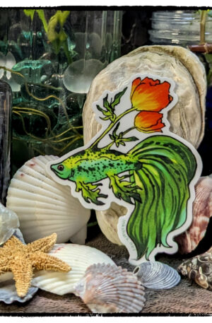 Sticker of a green betta with poppies growing from its back, posed on a backdrop of seashells and witchy jars
